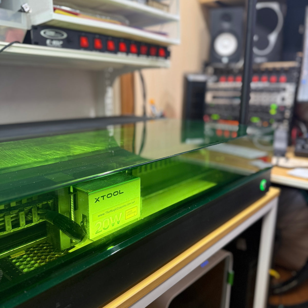 Green 3D printer on a desk with XTOOL branding in a workshop setting